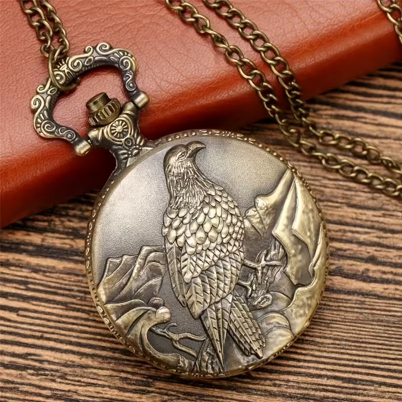 Reloj de bolsillo con un águila en relieve entre montañas y cadena