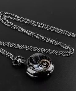 Reloj de dragones yin yang junto a su cadena sobre un fondo oscuro