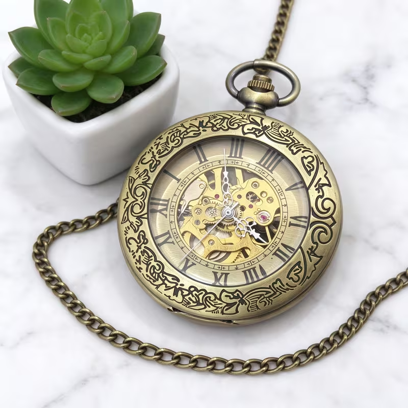 Reloj de arabescos con cadena sobre una superficie clara