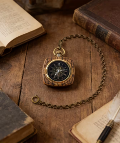 Reloj mecánico efecto madera con cadena en tono bronce sobre una mesa