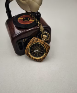 Reloj mecánico de acabado efecto madera junto a un objeto decorativo