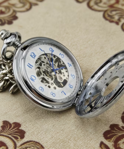 Reloj plateado abierto con números arábigos azules y centro mecánico visible