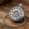 Reloj mecánico plateado con tapa de radios y engranajes decorativos