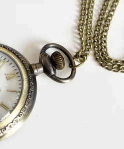 Detalle de la corona, el borde decorado y la cadena del reloj