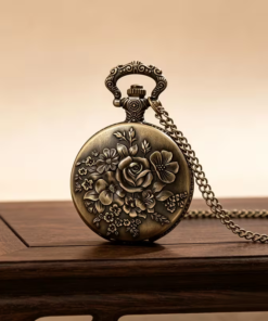 Reloj de rosa floral con cadena sobre una mesa de madera
