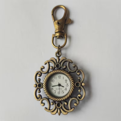 Reloj llavero con marco floral abierto en tono bronce y esfera blanca