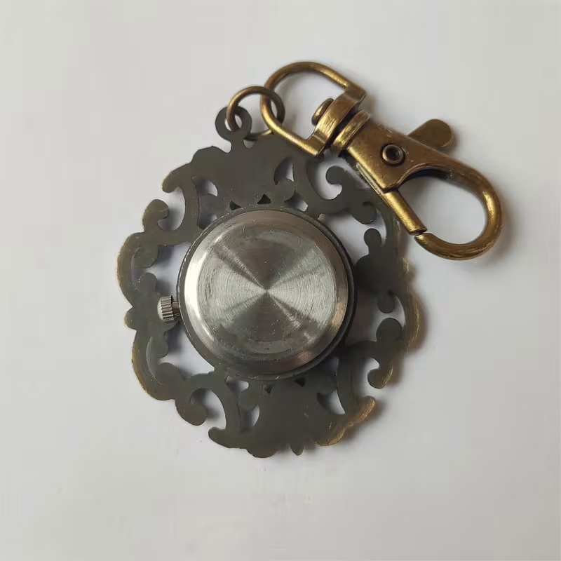 Parte posterior del reloj floral con tapa circular y corona lateral